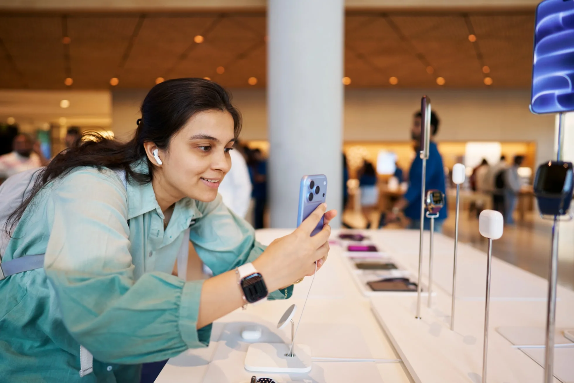 Cliente testa o iPhone 18 Pro e o AirPods 5 numa loja da Apple em Mumbai