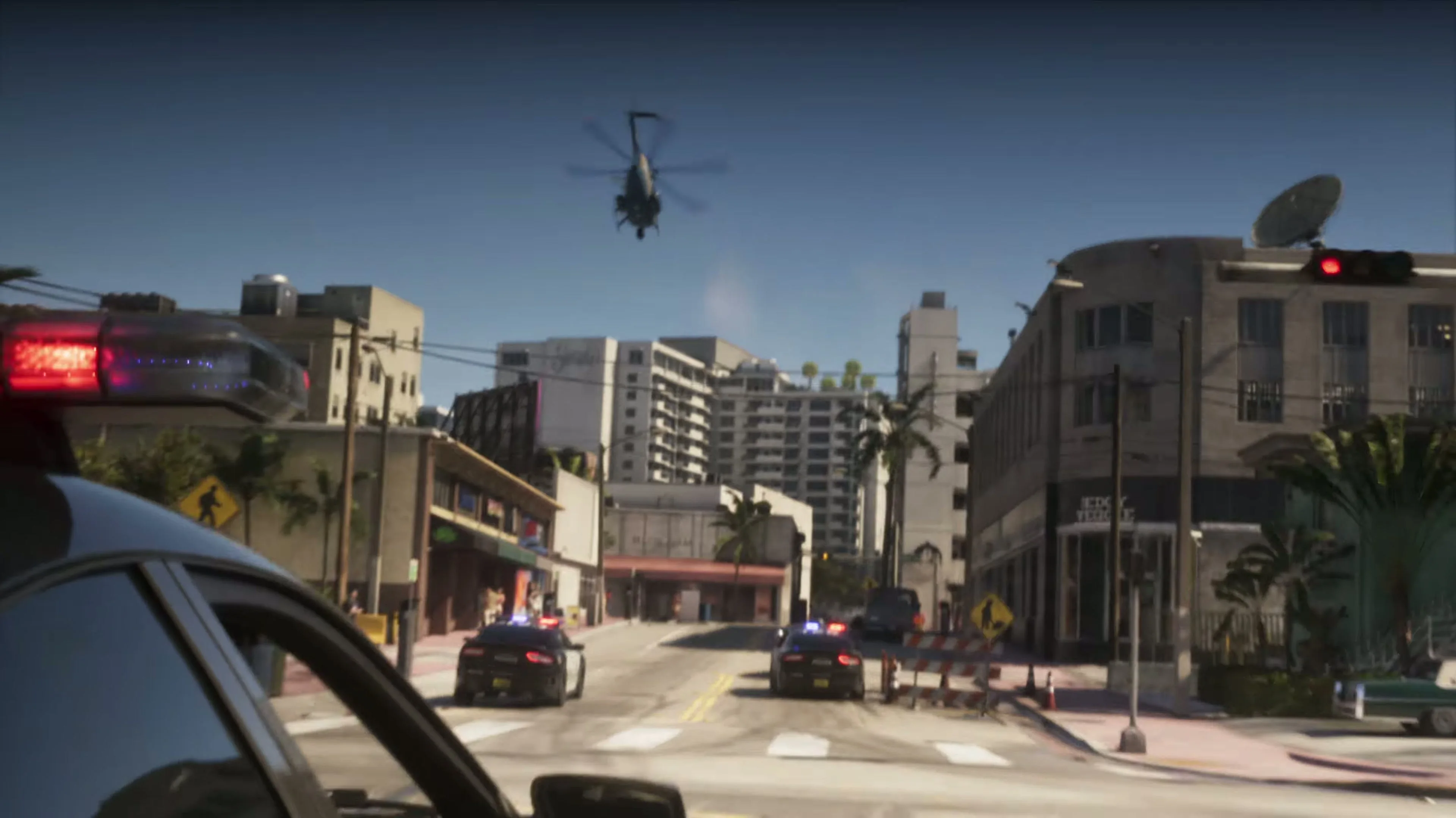 Cena de perseguição policial em GTA VI, com viaturas e helicóptero sobre uma rua da cidade, still do Extended Look