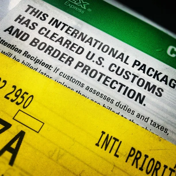 Etiqueta de pacote internacional liberado pela alfândega, com aviso sobre taxas e impostos
