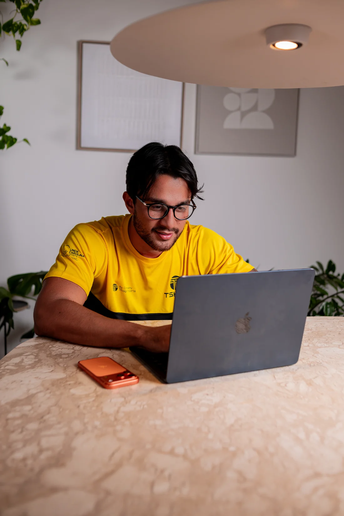 Thiago trabalhando no laptop, na mesa do escritório